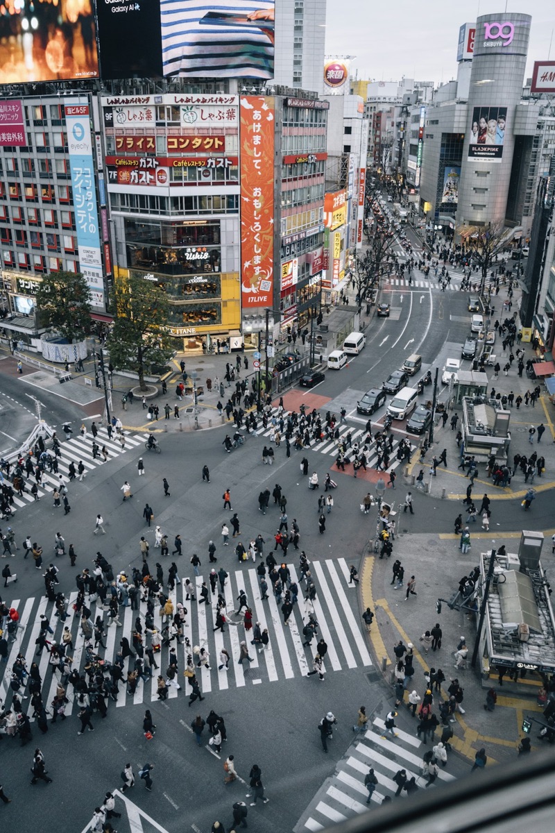 A bustling Shibuya Crossing in Tokyo with many pedestrians during peak season