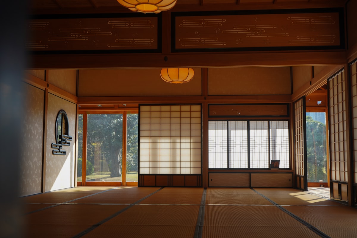 A spacious traditional Japanese ryokan room with shoji screens and tatami mats