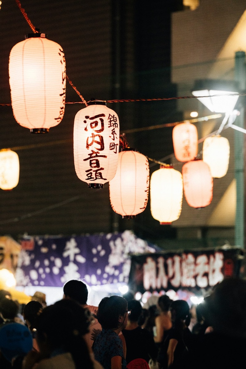 Glowing Japanese paper lanterns at a summer festival at night