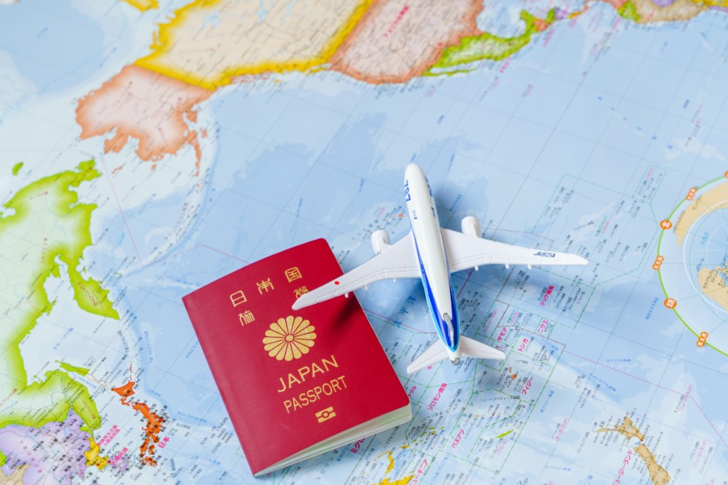 A Japanese passport and a model aircraft resting on a world map