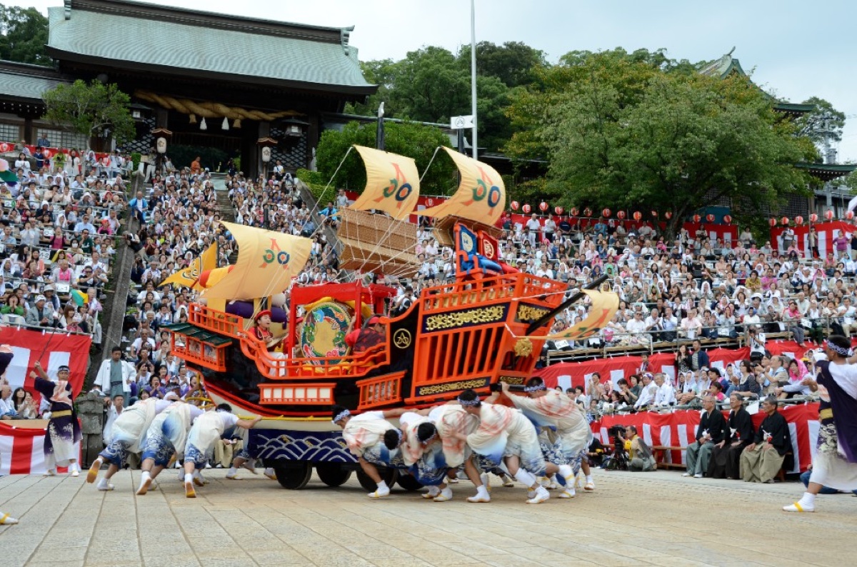 Festival ship float being pulled by performers in front of Suwa Shrine during Nagasaki Kunchi