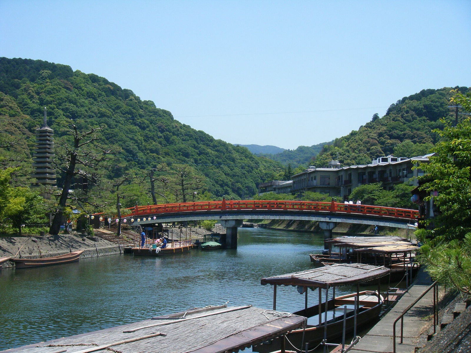 A red bridge, riverboats and green hills beside the Uji River islands